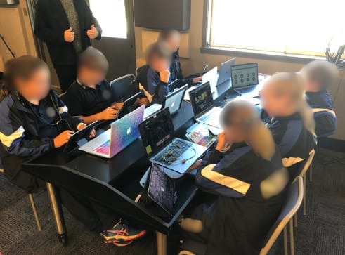Multiple student workstations with computers, headphones, and music software.