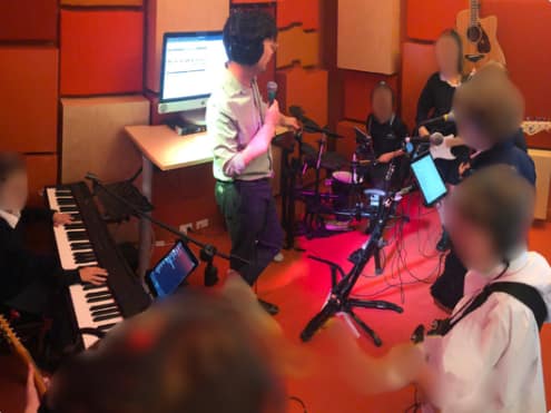 Small rehearsal space with instruments and soundproofing for group practice.
