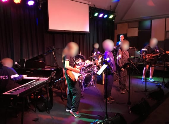 Performance stage with lighting, instruments, and audio system for student showcases.
